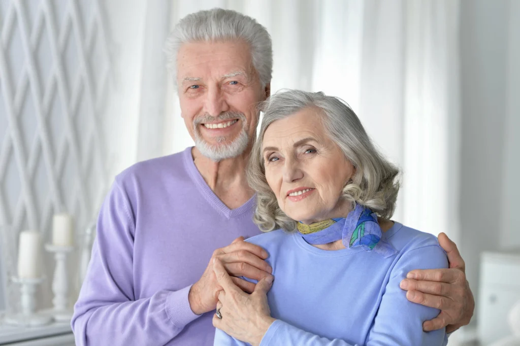 happy senior couple hugging home min scaled