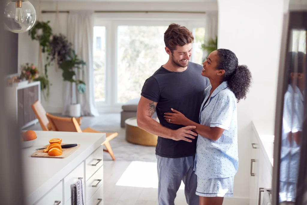 loving couple wearing pyjamas hugging kitchen home together min scaled (1)